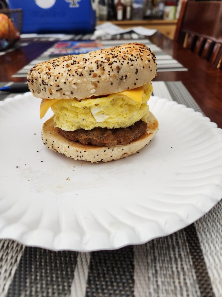 A towering breakfast bagel with turkey bacon, fluffy scrambled egg, cheese, and an everything bagel.