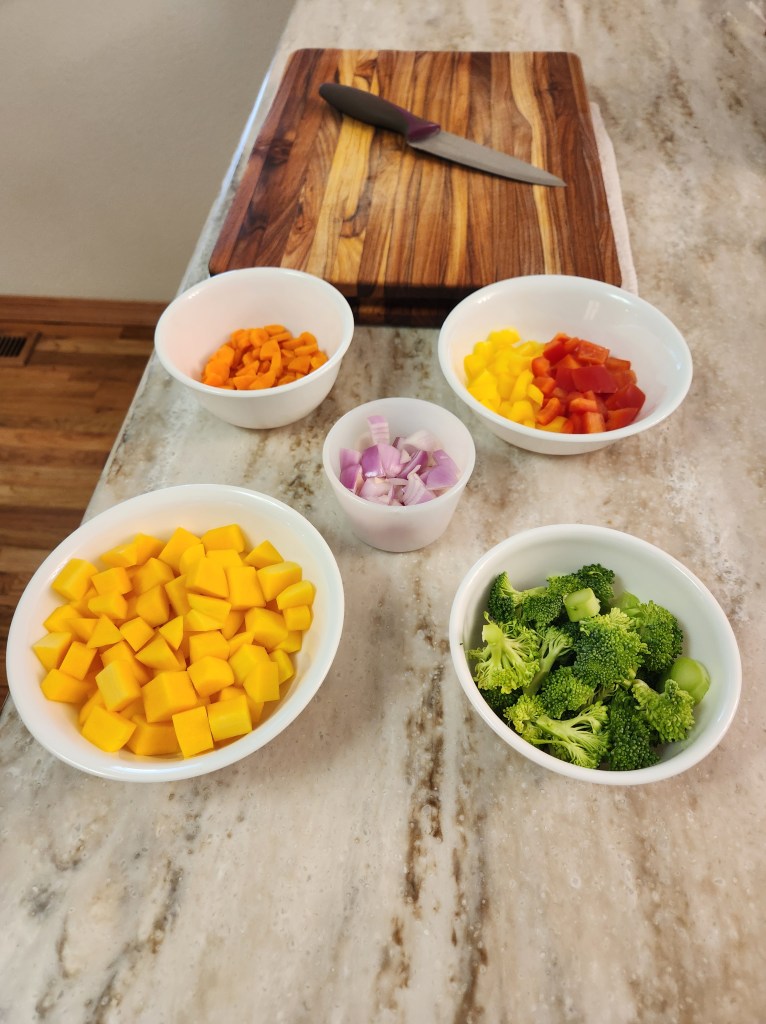 The beginnings of Chef Jamie's rainbow chicken dish, with yellow and red peppers, broccoli,purple onion, carrots, and yellow squash.