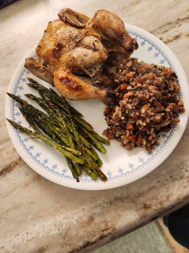 A perfectly roasted cornish gam hen with a wild rice pilaf and asparagus sauteed to perfection.