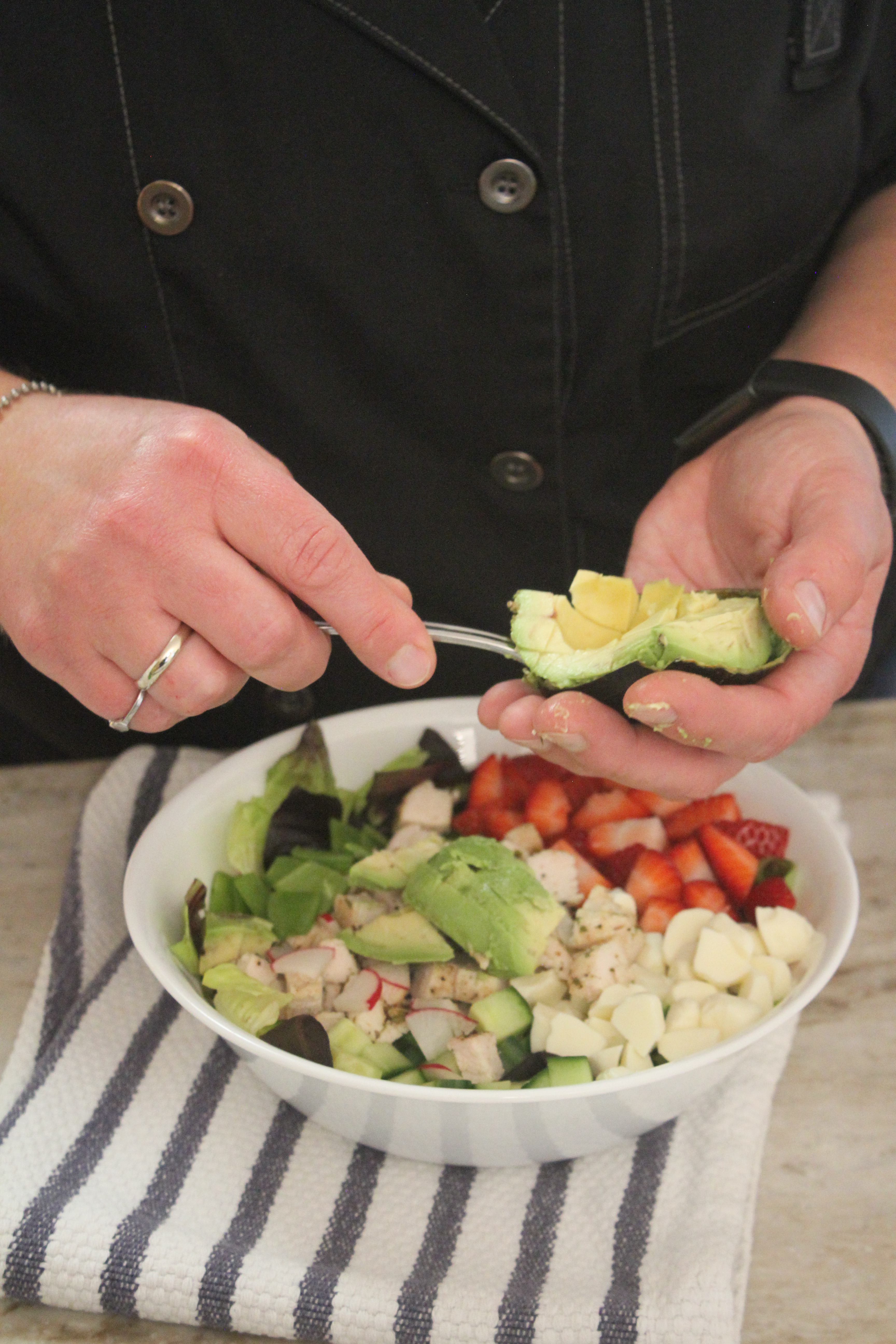 Chef Jamie scooping avocado onto her strawberry fields salad.